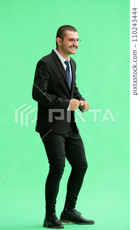 full-length portrait of a young man. standing isolated on green background full-length portrait of a young man. standing isolated on green background 110243444