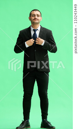 full-length portrait of a young man. standing isolated on green background 110243449