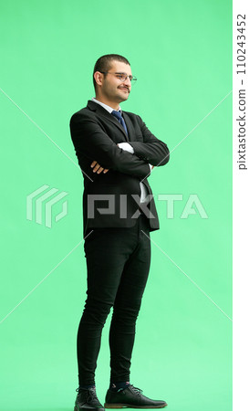full-length portrait of a young man. standing isolated on green background 110243452