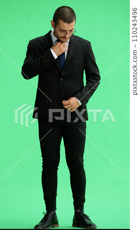 full-length portrait of a young man. standing isolated on green background full-length portrait of a young man. standing isolated on green background 110243496