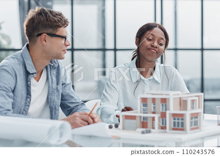 young man and woman designers architects discussing house designs young man and woman designers architects discussing house designs 110243576