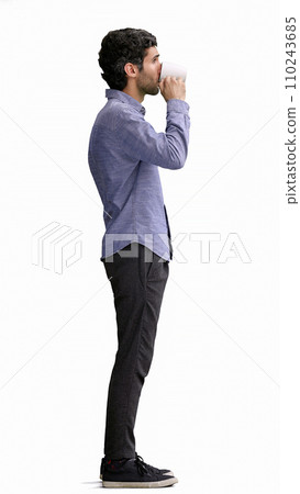 young man in full growth. isolated on white background. holding a mug of coffee 110243685