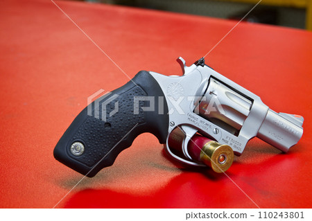 Close-Up of Loaded .22 Magnum Revolver on Red Surface 110243801