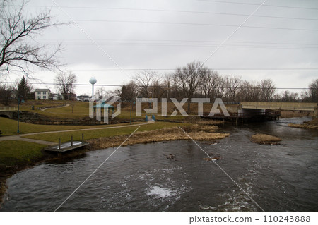 Tranquil River Park with Wooden Dock and Footbridge in Town Ann Arbor, Michigan 110243888