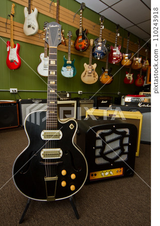 Classic Black Electric Guitar in Foreground of Diverse Music Store Collection 110243918