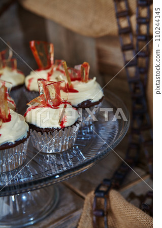 Gourmet Chocolate Cupcakes with Red Glass Candy in Rustic Setting 110244145