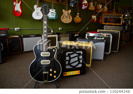 Music Store Interior with Focus on Black Electric Guitar and Amplifiers Music Store Interior with Focus on Black Electric Guitar and Amplifiers 110244148