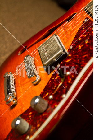 Sunburst Electric Guitar Detail in Warm Indoor Lighting with Glittery Edge 110244176