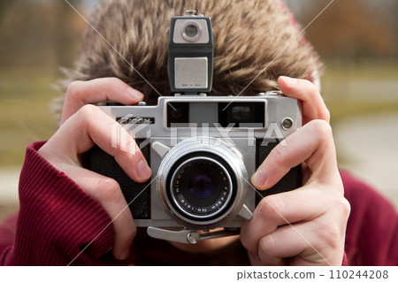 Female Photographer Capturing Winter Scenery with Vintage Film Camera Female Photographer Capturing Winter Scenery with Vintage Film Camera 110244208