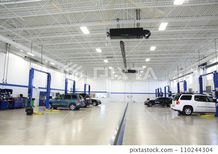 Modern Vehicle Service Center Interior with Blue Car Lifts 110244304