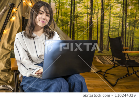 Workation A young woman working at a campsite 110244329