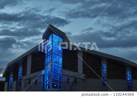 Twilight Glow on Modern Church with Blue Illumination and Dramatic Sky 110244369