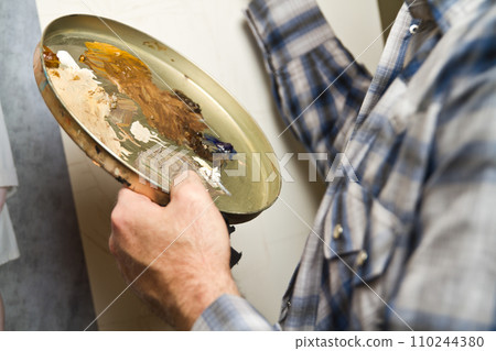 Close-Up of Artist's Hands Holding Oil Paint Palette in Studio Setting Close-Up of Artist's Hands Holding Oil Paint Palette in Studio Setting 110244380