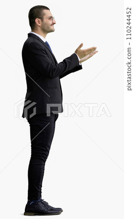 young man in full growth. isolated on white background demonstrates with hands 110244452
