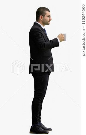 young man in full growth. isolated on white background. holding a mug of coffee young man in full growth. isolated on white background. holding a mug of coffee 110244500