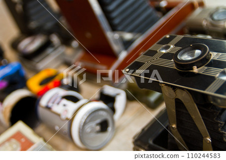 Close-up of Vintage Camera with Faded Equipment in Background 110244583
