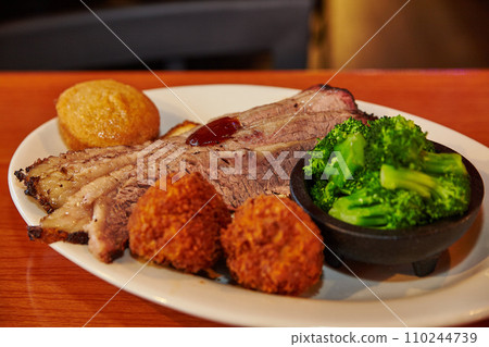 Hearty Southern BBQ Feast with Brisket and Hushpuppies in Restaurant Setting 110244739