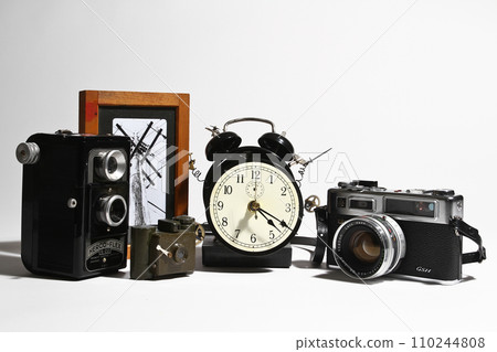 Vintage Camera Collection with Analog Clock and Artistic Photo on White Background Vintage Camera Collection with Analog Clock and Artistic Photo on White Background 110244808