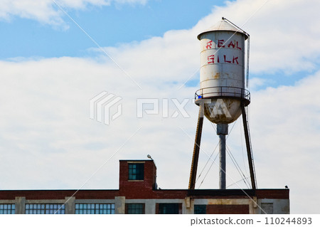 Vintage Real Silk Water Tower Over Industrial Brick Building in Indianapolis 110244893
