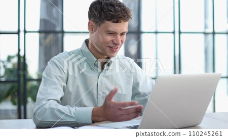 Shot of a young businessman using a laptop in a modern office 110245261