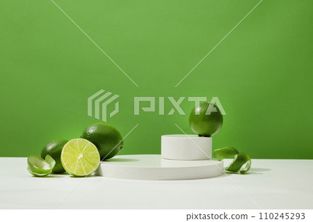 Fresh lemons are decorated around the display platform on a white surface with a green background. Copy space with front view for advertising. Fresh lemons are decorated around the display platform on a white surface with a green background. Copy space with front view for advertising. 110245293