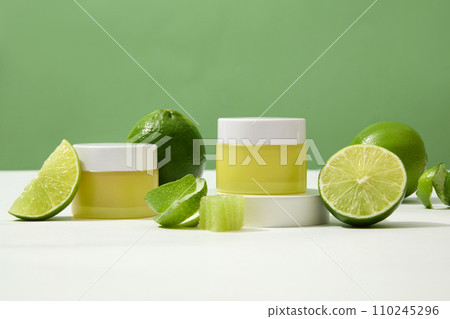 Pair of unbranded yellow cosmetic jars showcased on a white surface with fresh lemons. Blank labels offer space for custom lettering design, perfect for branding. 110245296