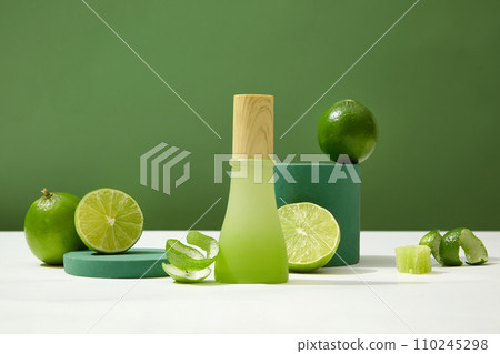 A homemade cosmetic bottle, adorned with a wooden lid, sits amidst fresh lemons on a white surface. Embodying a beauty concept enriched with the essence of natural ingredients. 110245298