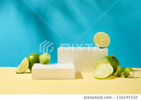 Fresh lemons with white podiums stand out on a blue background with space for product display. Thanks to the amount of natural acid, fresh lemon has the ability to exfoliate very effectively. 110245310