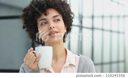 Cheerful woman enjoying coffee cup Cheerful woman enjoying coffee cup 110245356