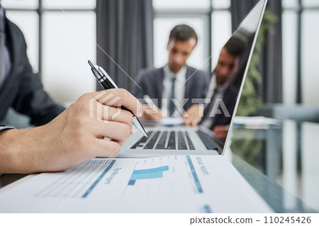 Closeup view of businessman working at sunny office on modern laptop Closeup view of businessman working at sunny office on modern laptop 110245426