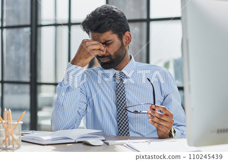 Tired stressed business man take off glasses fatigued of computer syndrome feel pain in dry eye Tired stressed business man take off glasses fatigued of computer syndrome feel pain in dry eye 110245439