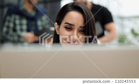Woman concentrating as she works on a laptop 110245553