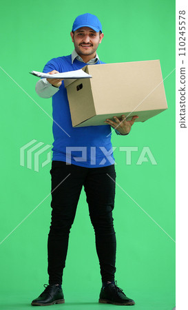 full-length male courier holding a box on a green background 110245578