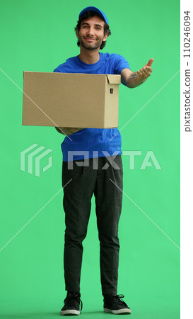 full-length male courier holding a box on a green background full-length male courier holding a box on a green background 110246094
