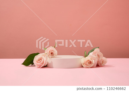 Roses are decorated around a podium on a pink background. Ideal space for cosmetics display. Beauty theme for advertising. Copy space with front view. Roses are decorated around a podium on a pink background. Ideal space for cosmetics display. Beauty theme for advertising. Copy space with front view. 110246662