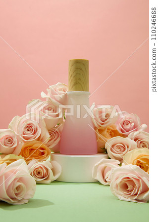 Pink background, roses, and a displayed bottle of homemade cosmetics. Rose water helps cleanse facial skin naturally, prevent and treat acne, and make skin soft and smooth. 110246688