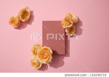 Each bunch of fresh roses is decorated around a podium on a pink background. Free space for displaying products with natural extracts. Top view. Each bunch of fresh roses is decorated around a podium on a pink background. Free space for displaying products with natural extracts. Top view. 110246718