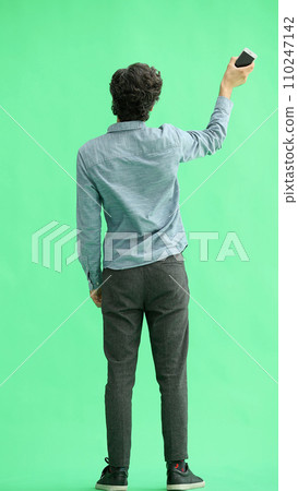young man in full growth. isolated on green background rejoices young man in full growth. isolated on green background rejoices 110247142
