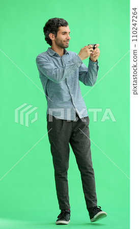 young man in full growth. isolated on green background taking selfie young man in full growth. isolated on green background taking selfie 110247264