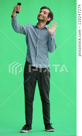 young man in full growth. isolated on green background taking selfie 110247274