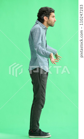 young man in full growth. isolated on green background profile young man in full growth. isolated on green background profile 110247283