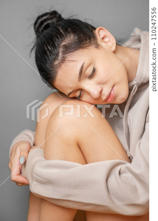 Pensive thoughtful young girl wearing sweatshirt with hood 110247556