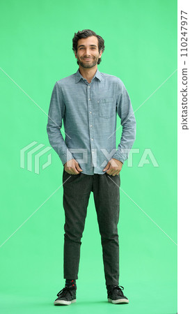 full-length portrait of a young man. standing isolated on green background full-length portrait of a young man. standing isolated on green background 110247977