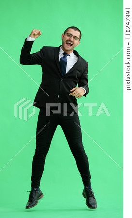 man in full growth. isolated on green background jumping rejoices man in full growth. isolated on green background jumping rejoices 110247991