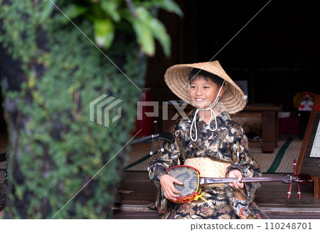 穿著沖繩民俗服裝畫三線的男孩 穿著沖繩民俗服裝畫三線的男孩 110248701