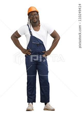 A man in a work uniform, on a White background, in full height, holds his hands on his belt 110249414