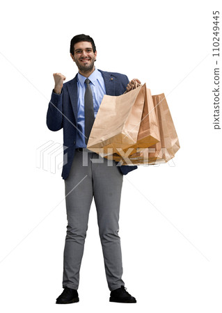 A man in an office suit with bags in his hands on a White background 110249445