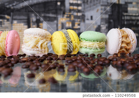 French macaroons, coffee beans and a cup of black coffee on the table close-up. 110249508