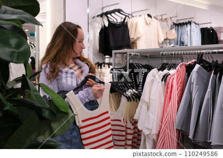 shopping at hm choosing clothes paying at the checkout standing in line several videos of a young teenage girl buying a fashionable outfit ripped jeans lilac blouse loose hair shopping at hm choosing clothes paying at the checkout standing in line several videos of a young teenage girl buying a fashionable outfit ripped jeans lilac blouse loose hair 110249586