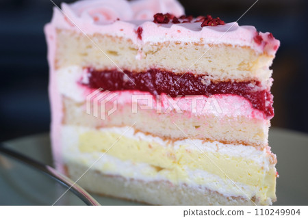 close-up of a piece of cake with cherries being unwrapped from the package. bakery cake. appetizing piece of cake with cherry. selective focus 110249904